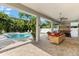 Expansive outdoor living area featuring a pool, spa, bar, and comfortable seating, perfect for relaxing and entertaining at 322 Ontario Ave, Crystal Beach, FL 34681