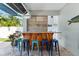Outdoor bar area with seating and mounted surfboards, perfect for entertaining guests and enjoying the backyard at 322 Ontario Ave, Crystal Beach, FL 34681