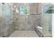 Stunning bathroom featuring glass shower doors, a tiled shower, and a built-in bench at 322 Ontario Ave, Crystal Beach, FL 34681