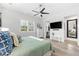 Bright bedroom with wood floors, ensuite bathroom, modern dresser and ceiling fan at 322 Ontario Ave, Crystal Beach, FL 34681