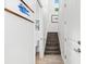 Bright hallway with staircase, tiled floor, and interesting artwork leading to the second floor at 322 Ontario Ave, Crystal Beach, FL 34681