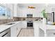 Modern kitchen with white cabinetry, stainless steel appliances, and light wood flooring at 322 Ontario Ave, Crystal Beach, FL 34681
