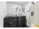 Modern laundry room featuring a new washer and dryer and overhead rack at 322 Ontario Ave, Crystal Beach, FL 34681