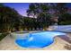 Inviting backyard with a sparkling pool, hot tub, lounge chairs, and mature landscaping at 322 Ontario Ave, Crystal Beach, FL 34681