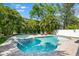 Inviting backyard pool and spa surrounded by lush, tropical landscaping, creating a private oasis at 322 Ontario Ave, Crystal Beach, FL 34681