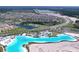An aerial view of the community featuring a lagoon, pools, clubhouse, and surrounding residences at 32573 Turtle Grace Loop, Wesley Chapel, FL 33545