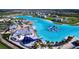 A captivating aerial view of a luxurious community with vibrant blue lagoon, beach club and resort-style amenities at 32573 Turtle Grace Loop, Wesley Chapel, FL 33545