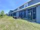 Exterior view of a blue home with a well-maintained lawn and screened patios at 32573 Turtle Grace Loop, Wesley Chapel, FL 33545
