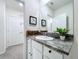Well-lit bathroom featuring granite countertop, white cabinetry, and decorative 'Personal Cave' sign at 32573 Turtle Grace Loop, Wesley Chapel, FL 33545