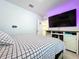 Bedroom with decorative television, white walls, with access to the laundry room at 32573 Turtle Grace Loop, Wesley Chapel, FL 33545