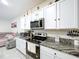 Well-lit kitchen featuring granite countertops, stainless steel appliances, and white cabinetry at 32573 Turtle Grace Loop, Wesley Chapel, FL 33545