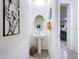 Cozy powder room with a pedestal sink, decorative mirror, and neutral decor at 32573 Turtle Grace Loop, Wesley Chapel, FL 33545