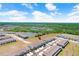 New townhomes with beige roofs have assigned parking, along a pond and a green wooded area in the distance at 32978 Tulip Petal Ln, Wesley Chapel, FL 33545