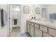 Bathroom featuring double sinks, vanity, and a walk-in shower with glass door at 32978 Tulip Petal Ln, Wesley Chapel, FL 33545