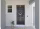 Elegant entryway boasting a black front door with decorative wreath, welcome mat and small window at 32978 Tulip Petal Ln, Wesley Chapel, FL 33545