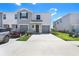 Two-story townhome with a two-car garage, gray accents, and well-maintained landscaping at 32978 Tulip Petal Ln, Wesley Chapel, FL 33545