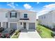 Two-story townhome with a two-car garage, gray accents, and well-maintained landscaping at 32978 Tulip Petal Ln, Wesley Chapel, FL 33545