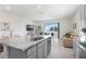 Bright kitchen featuring granite countertops, a central island, and a view into the living area at 32978 Tulip Petal Ln, Wesley Chapel, FL 33545