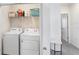 Laundry area with a washer, dryer, shelving for storage, and a view into the hallway at 32978 Tulip Petal Ln, Wesley Chapel, FL 33545