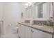 Bright bathroom featuring double sinks with white cabinets and granite counters, offering ample space at 409 Regent N Ln, St Petersburg, FL 33701