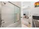 En-suite bathroom with white tiled shower and glass doors leading into an office space with natural light at 409 Regent N Ln, St Petersburg, FL 33701
