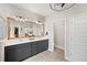 Stylish bathroom with dual sinks, a large framed mirror, and modern lighting fixtures at 4108 Mellon Dr, Odessa, FL 33556