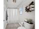 Bathroom with toilet, shower with curtain, and decorative toilet paper storage at 4108 Mellon Dr, Odessa, FL 33556