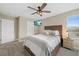 This bedroom includes a wooden headboard, ceiling fan, and natural light from the window at 4108 Mellon Dr, Odessa, FL 33556