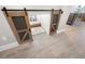 Unique and cozy dog room with barn doors, patterned wallpaper, comfortable bedding, and tile flooring at 4108 Mellon Dr, Odessa, FL 33556