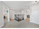 Hallway area featuring carpeting, doorways, and dark-stained railing and banister at 4108 Mellon Dr, Odessa, FL 33556