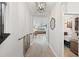 Hallway featuring tile flooring, access to a laundry room, and a view into the living room at 4108 Mellon Dr, Odessa, FL 33556