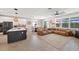 Spacious open-concept living area with modern kitchen, dining space, and comfortable leather seating with natural light at 4108 Mellon Dr, Odessa, FL 33556