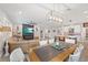 Expansive living area with a rustic dining table, leather seating, modern lighting, and an open layout to the kitchen at 4108 Mellon Dr, Odessa, FL 33556