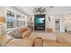 Cozy living room featuring a stone fireplace, large windows, and comfortable tan leather sectional sofa at 4108 Mellon Dr, Odessa, FL 33556