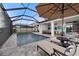 Relaxing screened-in pool area with lounge chairs, umbrella and cozy covered seating at 4108 Mellon Dr, Odessa, FL 33556