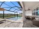 Relaxing screened in pool area with a cozy covered seating area and open views at 4108 Mellon Dr, Odessa, FL 33556