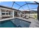 Gorgeous screened-in pool and patio area with ample seating and charming string lights at 4108 Mellon Dr, Odessa, FL 33556