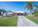 Single-story home with metal roof, lush landscaping and a spacious driveway at 4220 Floramar Ter, New Port Richey, FL 34652