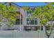 Rear exterior view with large windows, a covered patio, and a privacy fence, offering a modern and secluded outdoor living space at 4806 W Melrose Ave, Tampa, FL 33629