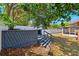 Backyard with steps to a deck, screened lanai, shed, and white fence, offering a perfect blend of relaxation and outdoor activities at 506 Spring Tree Ct, Tarpon Springs, FL 34689