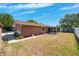 Backyard with lush lawn, enclosed lanai, wood shed, and white fencing, a perfect Gathering space at 506 Spring Tree Ct, Tarpon Springs, FL 34689