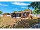 Backyard showcasing lanai, shed, well-maintained lawn, and white fencing at 506 Spring Tree Ct, Tarpon Springs, FL 34689