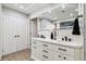 Bright bathroom featuring double sinks, white cabinets, and a large, illuminated mirror at 506 Spring Tree Ct, Tarpon Springs, FL 34689