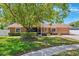 Charming single-story home featuring a lush front yard with mature landscaping and a welcoming screened entrance at 506 Spring Tree Ct, Tarpon Springs, FL 34689