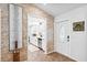 Inviting hallway with decorative stone wall leading to a bright, modern kitchen with white cabinetry at 506 Spring Tree Ct, Tarpon Springs, FL 34689
