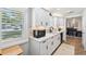 Updated kitchen with white cabinetry, stainless steel appliances, and abundant natural light through shuttered windows at 506 Spring Tree Ct, Tarpon Springs, FL 34689