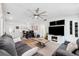 Spacious living area with a fireplace, modern entertainment center, and an adjacent dining space at 506 Spring Tree Ct, Tarpon Springs, FL 34689