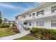 Inviting condo exterior with clean white facade, landscaped walkway, and stairs to upper-level units at 5915 18Th N St # 11, St Petersburg, FL 33714
