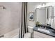 Bright bathroom featuring a shower-over-tub with neutral tile and a striking striped curtain at 5958 Talon Preserve Dr, Nokomis, FL 34275
