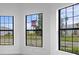A bright bedroom offers a view from its three large black-trimmed windows at 5958 Talon Preserve Dr, Nokomis, FL 34275
